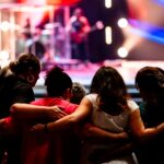 A diverse group embracing at a live music event, creating a sense of unity and togetherness.
